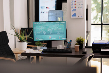 Monitor with analysis of business performance at office desk. Software showing trend of yearly statistics to follow business development in rate diagram, empty workplace.