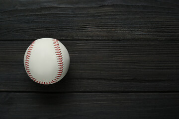 Baseball ball on black wooden table, top view with space for text. Sports game