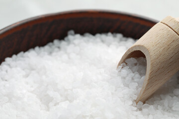 Fototapeta na wymiar Natural sea salt in wooden bowl and scoop, closeup