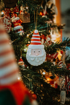 Santa Claus Christmas tree decoration ornament on a branch with lights on