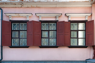 Three windows with shutters on the old building wall in Kyiv Ukraine