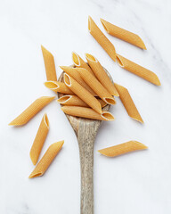 Raw pasta in wooden spoon on white background