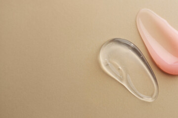 Samples of cosmetic gels on beige background, top view. Space for text