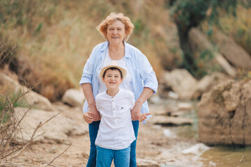 Grandma with her grandchildren by the sea on vacation. Grandparents with grandchildren spend time...