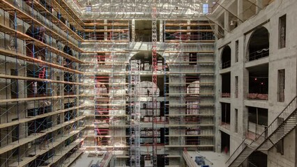 Panorama showing construction equipment material with scaffolding and tools inside the floor of high rising building timelapse, skyscraper. Building under construction. Interior work in progress.