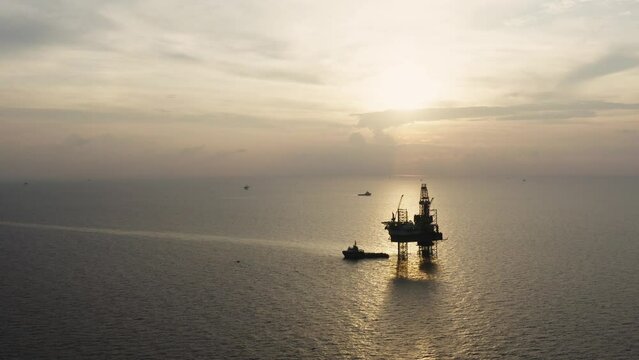 Jack up drilling rig and production platform in the middle of the ocean at sunrise time
