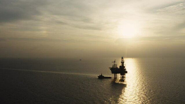 Jack up drilling rig and production platform in the middle of the ocean at sunrise time
