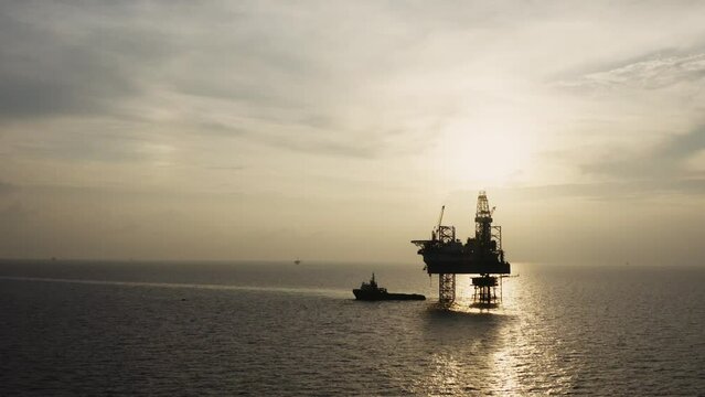 Jack up drilling rig and production platform in the middle of the ocean at sunrise time

