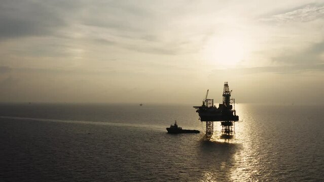 Jack up drilling rig and production platform in the middle of the ocean at sunrise time
