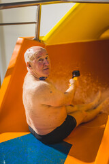 Vertical indoor shot of a modern brave caucasian grandfather in black shorts looking at camera...
