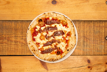 Great thin-crust Italian pizza with fried bacon strips with mozzarella cheese and tomato baked in a stone oven