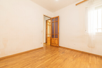 An empty room with french oak wood laminate flooring, matching skirting board and solid pine wood...