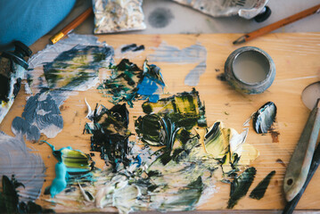 Close up of woman's hand mix paints in palette