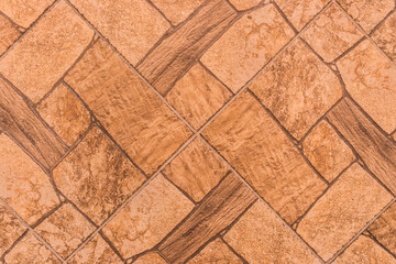 Brown tile floor with abstract pattern of stone texture orange background, top view