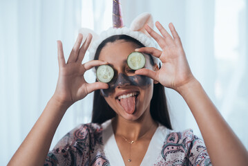 Funny smiling Spa Woman with fresh Facial Mask hold cucumbers.