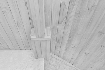 Modern interior with light wood ceiling and white plaster and brick walls background