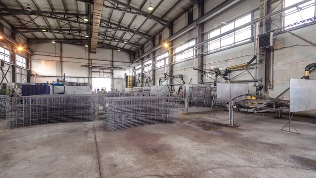 Welders working with electrode at semi-automatic arc welding in manufacture production plant timelapse. Worker in uniform and metal reinforcement on a factory