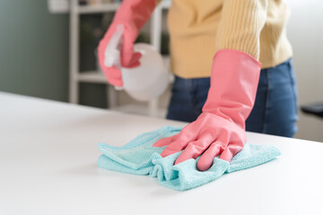 happy Female housekeeper service worker wiping table surface by cleaner product to clean dust.