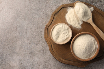 Bowls and spoon of agar-agar powder on grey table, top view. Space for text