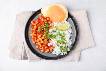 Delicious chickpea curry with rice and flatbread on light gray table, flat lay