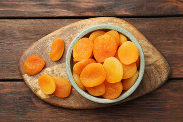 Bowl of tasty apricots on wooden table, top view. Dried fruits