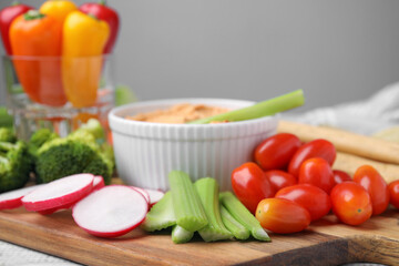 Board with delicious hummus and fresh vegetables, closeup