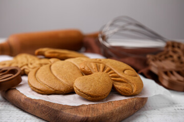 Tasty cookies and cutters on white wooden table, closeup