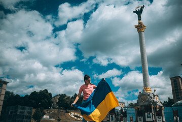 Young woman with national flag of Ukraine on the street