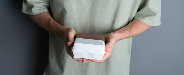 holding a paper box with a burger fast food, template copy space