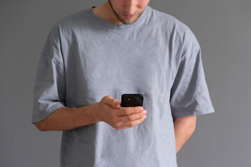 young guy holding smartphone, using social networks