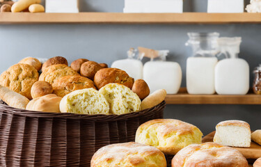 wicker basket of fresh baked bread over a counter, bakery product display, assortment of baked bread