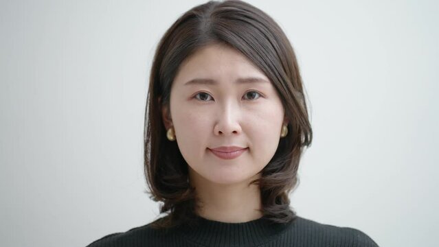 伏せた顔を上げる中年女性