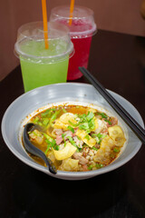 Yellow egg noodles in spicy pork soup