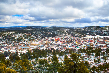 Fototapeta premium winter in village surrounded by mountains, snow covered the forest and hills, creel chihuahua 