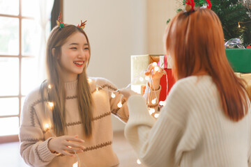Christmas decoration concept, Two women in reindeer horns playing christmas lights with happiness
