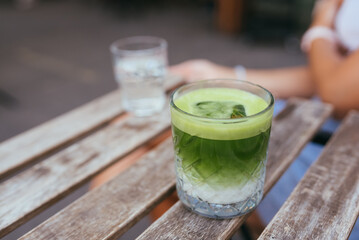 Iced green matcha latte tea on wooden table
