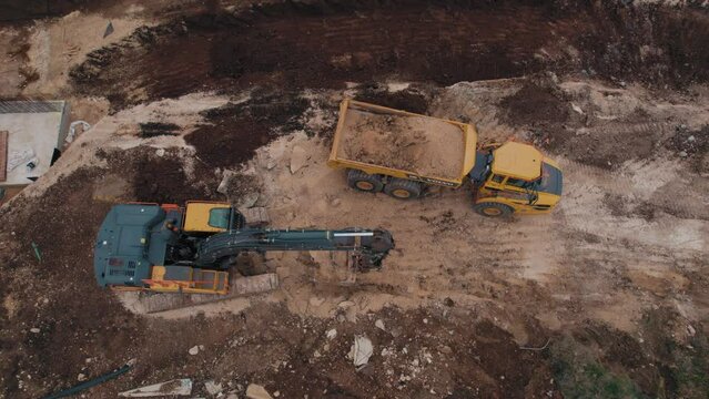 Top down view of volvo A30G articulated hauler +  EC380E crawler excavators - heavy earthwork construction #010