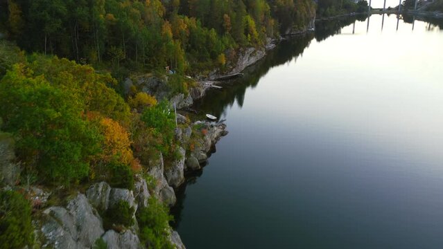 aerial top down of rocky cliffside overlooking river on Orust Island in Sweden at dusk