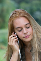 Girl immerses herself in listening to music outdoors