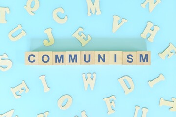 Communism government form concept. Wooden blocks typography flat lay in blue background.	