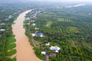 aerial view of Villa house in the middle of the garden with blue tile roof and the river at Mekong...