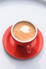 Cafe Latte Art, love shape on a cafe latte. Hot Cafe latte in a red cup