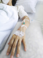 Asian woman patient receiving chemical drugs on drip to blood vessel solution to treat cancer.