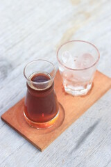 a glass of black coffe made using japanese technique and ice cubes in the morning