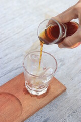 a glass of black coffe made using japanese technique and ice cubes in the morning