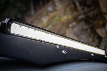 Close up of custom LED light bar on roof rack off road car.