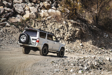 White SUV going down the mountainous rocky terrain. © Roman
