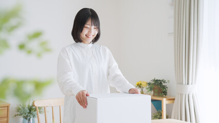 ダンボールを開ける女性（引越し・梱包）