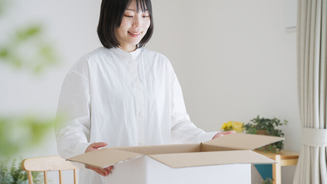 ダンボールを開ける女性（引越し・梱包）