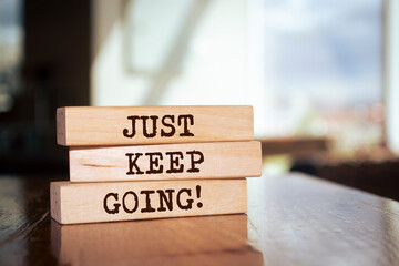 Wooden blocks with words 'Just keep going'. - obrazy, fototapety, plakaty